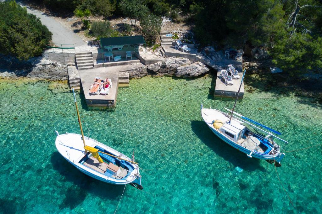 two boats are docked at a dock in the water at Apartments Triporte in Vela Luka