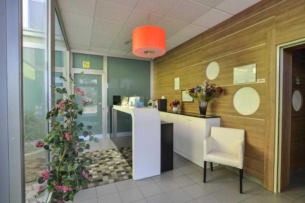 an office lobby with a reception desk and flowers at Motel S.16 in Muro Leccese