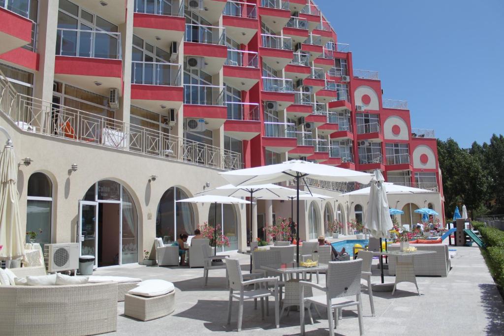 un hôtel avec des chaises et des parasols en face d'un bâtiment dans l'établissement Rose Garden Omax Apartments, à Sunny Beach