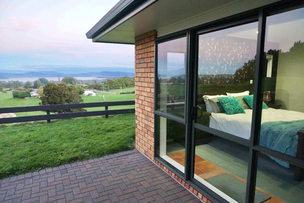 a room with a window with a bed and a view at Rotorua Lake View Villa in Hamurana