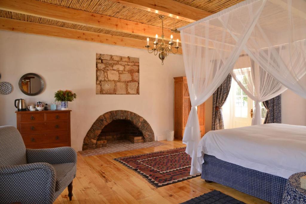 a bedroom with a bed and a fireplace at De Hoop Collection Suites in De Hoop Nature Reserve