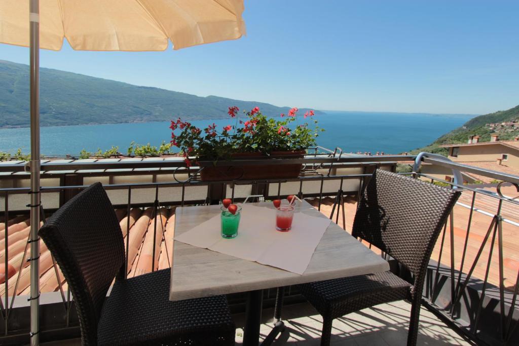 een tafel met twee drankjes op het balkon bij Al Terrazzo Apartments - Ruculì Hospitality in Tignale