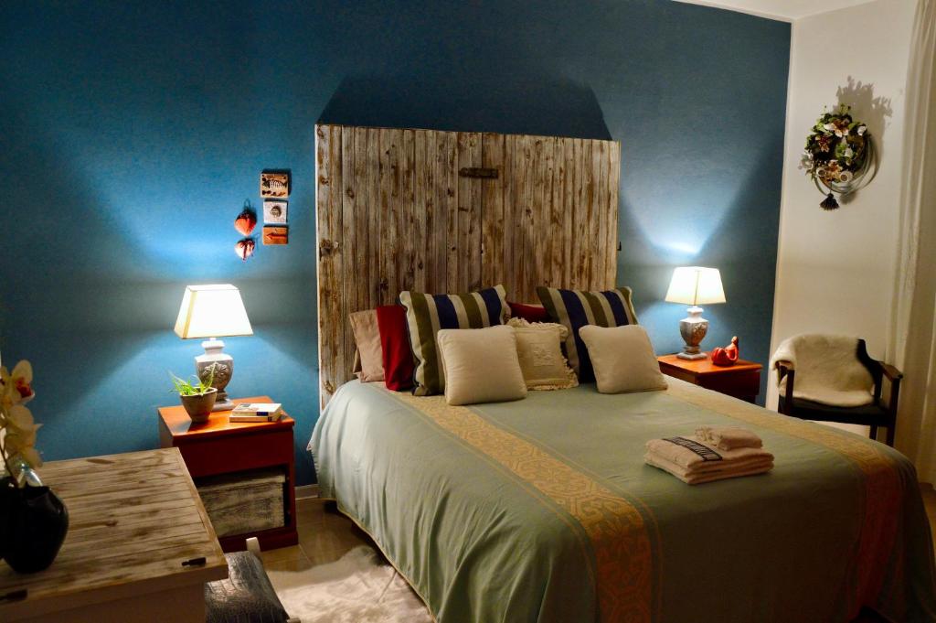 a bedroom with a large bed with blue walls at Prama 'e Mari in Oristano