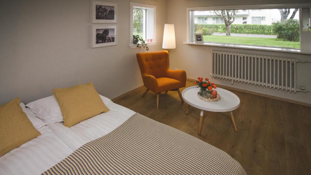 ein Schlafzimmer mit einem Bett, einem Stuhl und einem Tisch in der Unterkunft Apartment 19 in Selfoss
