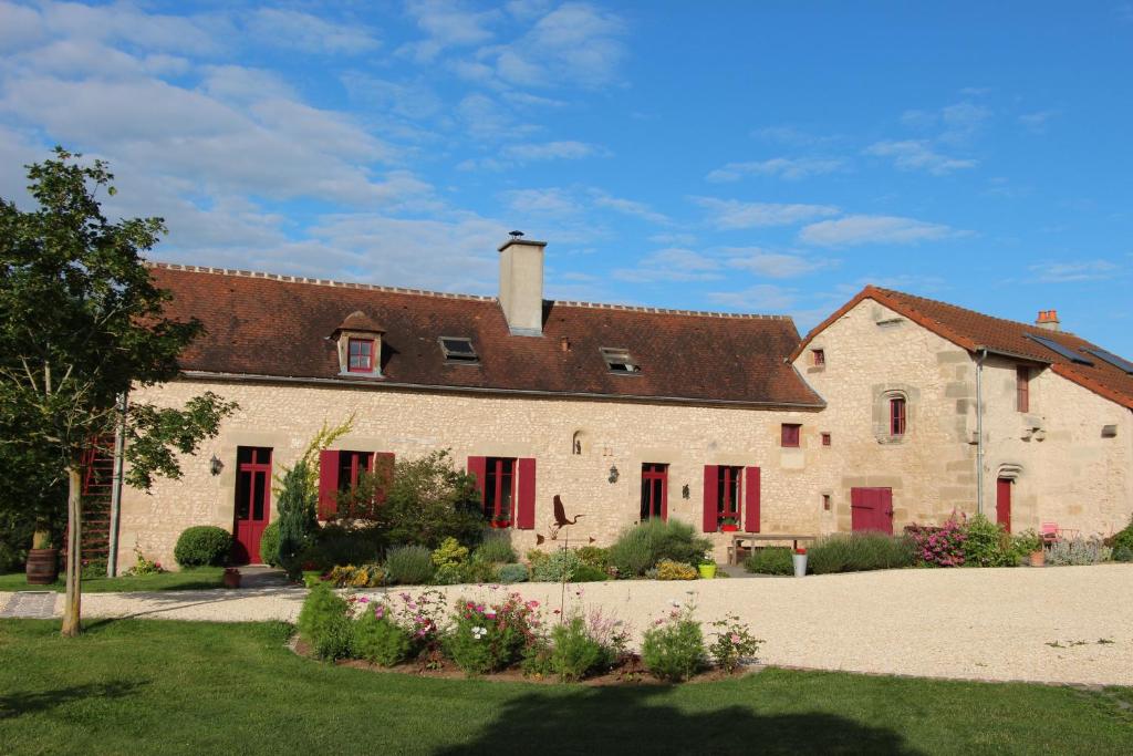 a large white building with red shuttered windows at La Troliere in Autry-Issards