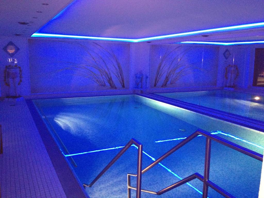 a swimming pool with blue lights in a room at Appartementresidenz am Kurpark in Bad Salzuflen