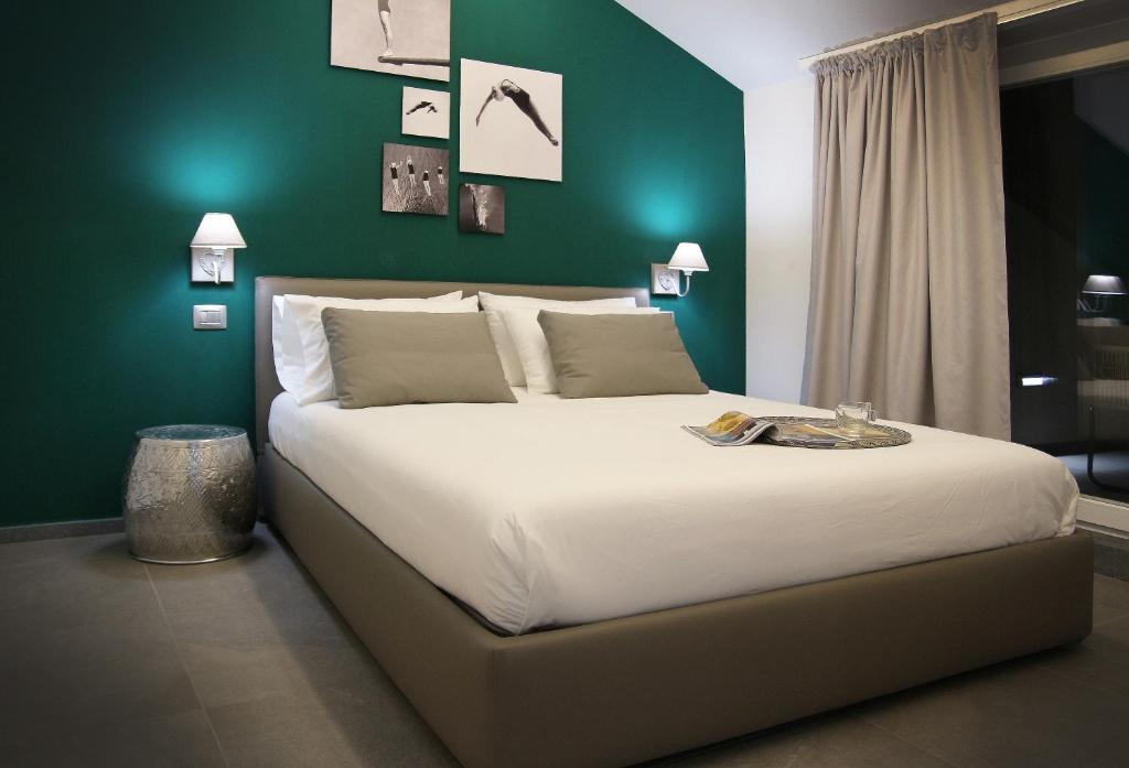 - une chambre avec un grand lit et un mur vert dans l'établissement Affittacamere Bellavista, à La Spezia