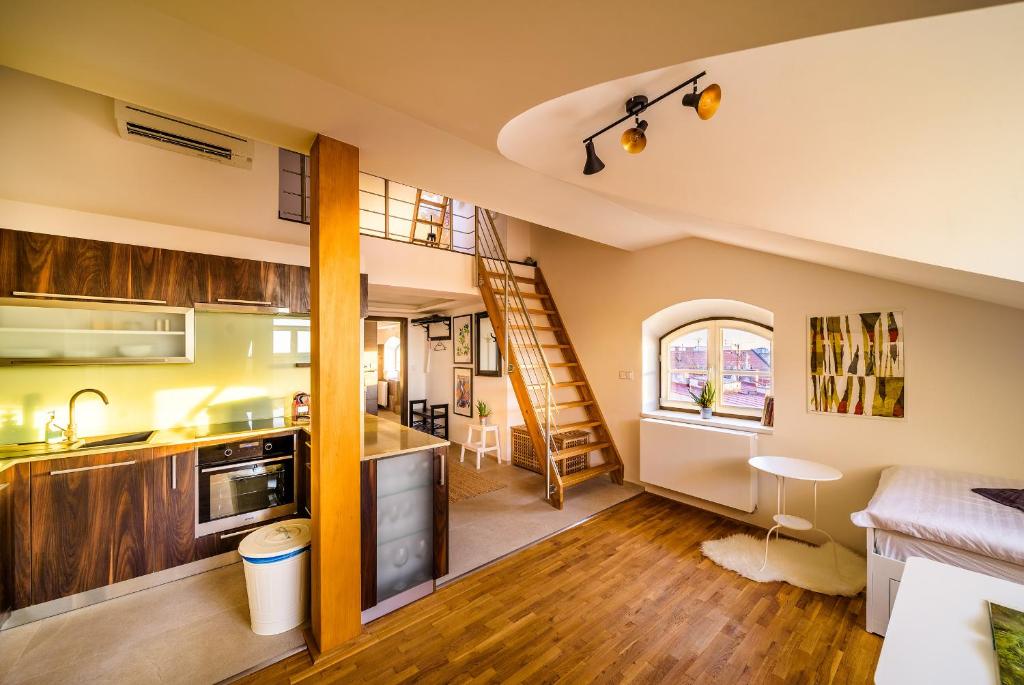 una cucina e un soggiorno con scala in una casa di Rooftop Triplex Apartment in Centre a Hradec Králové