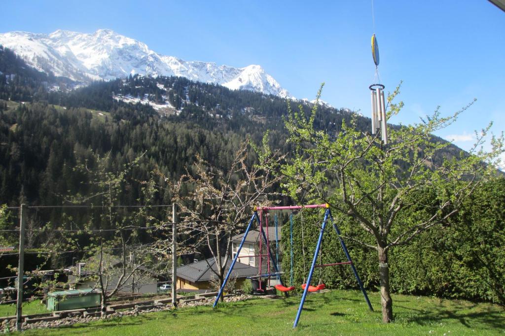a playground in a field with mountains in the background at B&B Gottardo in Airolo