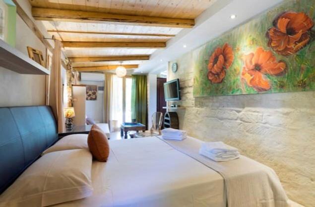 a bedroom with a large bed with a painting on the wall at B&B Asparano Anita Open Space in Ognina