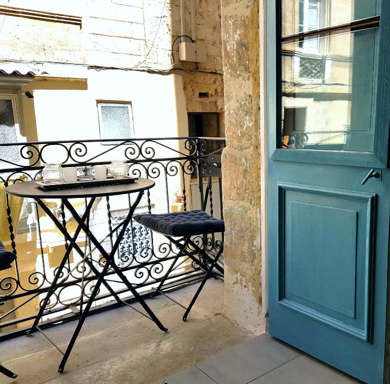 a table on a balcony next to a door at 88, Valletta Boutique Escape in Valletta