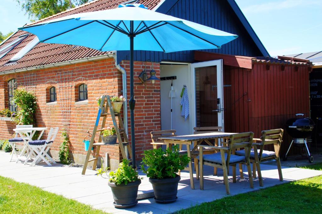 a table and chairs with an umbrella on a patio at Aarhus bugtens Perle in Malling