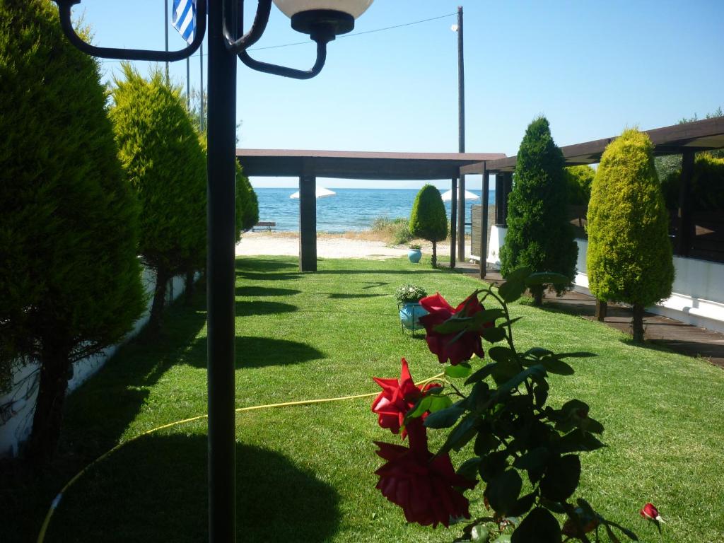 um jardim com vista para a praia em Hotel Dimitra em Tsoukalaíika