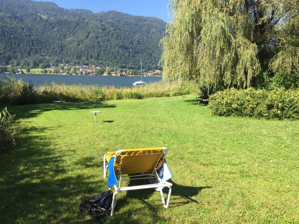 una sedia seduta sull'erba vicino a un lago di Haus Kärnten a Altossiach