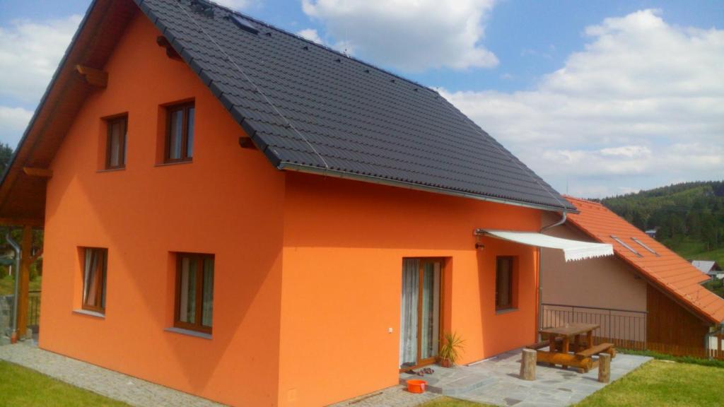 una casa naranja con techo negro en Holiday Home U Fišerů en Kašperské Hory