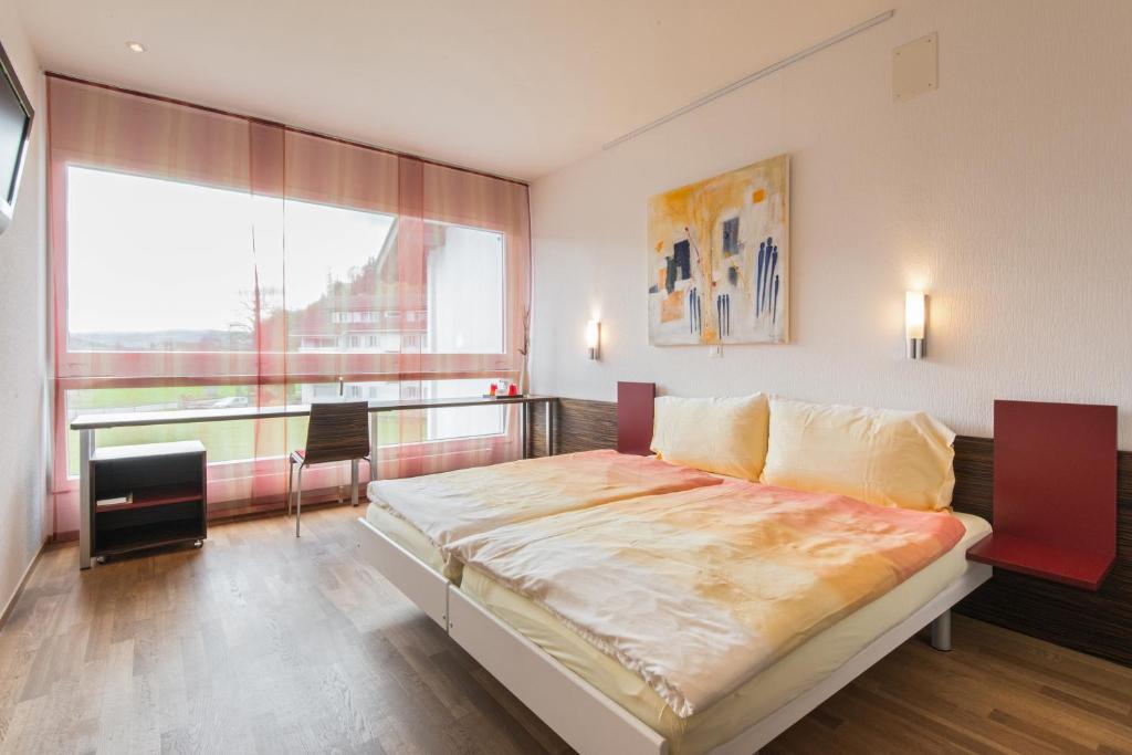 um quarto com uma cama grande e uma janela grande em Hotel Thorenberg em Lucerna