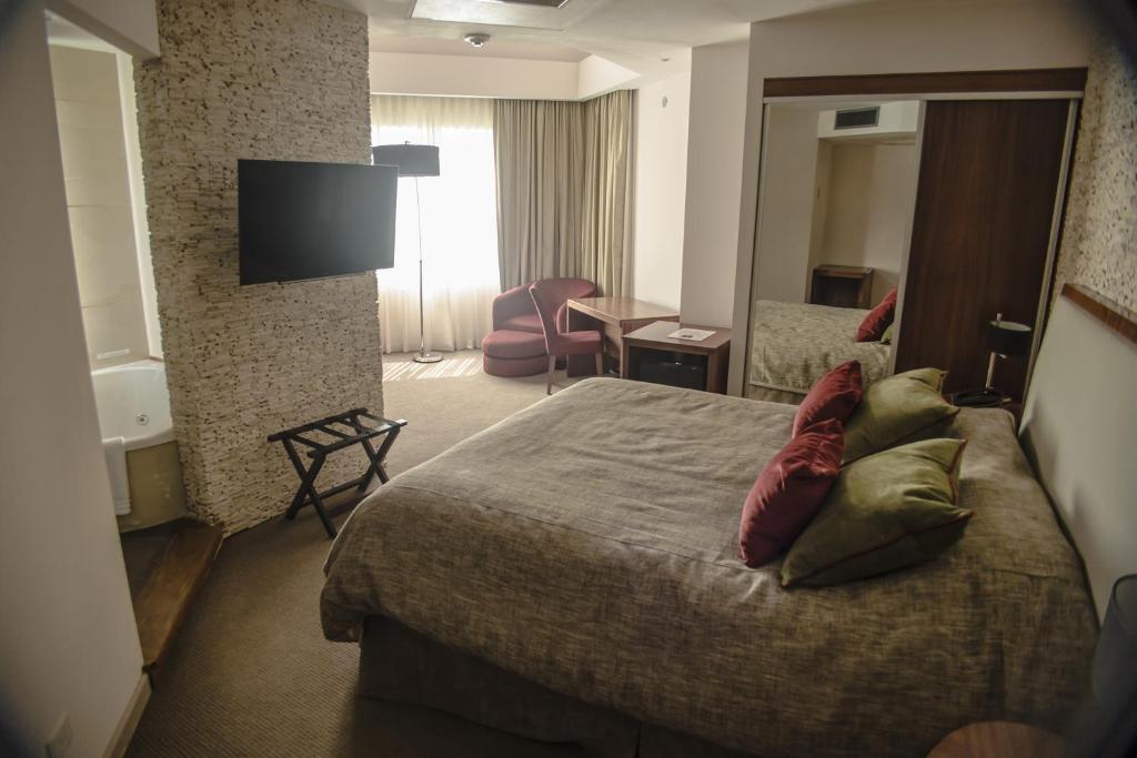 Habitación de hotel con cama y TV en Antu Malal Hotel en Plaza Huincul