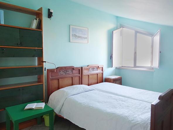 1 dormitorio con cama blanca y mesa verde en Solemare, en Montesilvano Marina