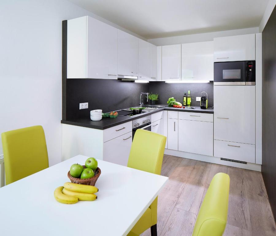 - une cuisine avec une table avec des bananes et des pommes dans l'établissement Good Rooms GmbH Bad Ischl, à Bad Ischl