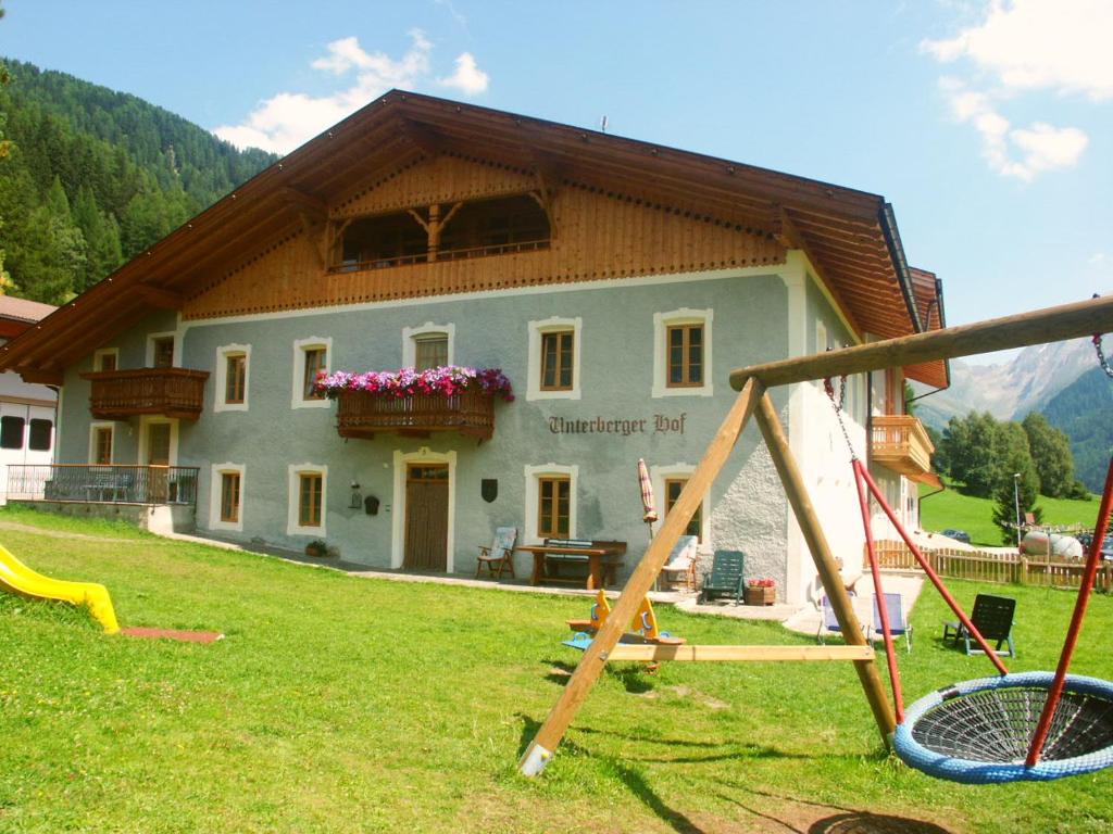 une maison avec une aire de jeux en face dans l'établissement Unterbergerhof, à Val di Vizze