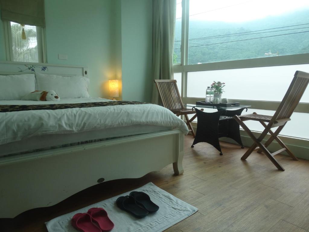 吉安的住宿－海石生活館，一间卧室配有一张床、两把椅子和一张桌子