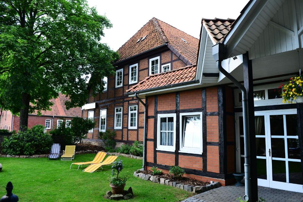 ein Haus mit einem Garten mit Stühlen und einem Haus in der Unterkunft Landhotel Michaelishof in Bergen