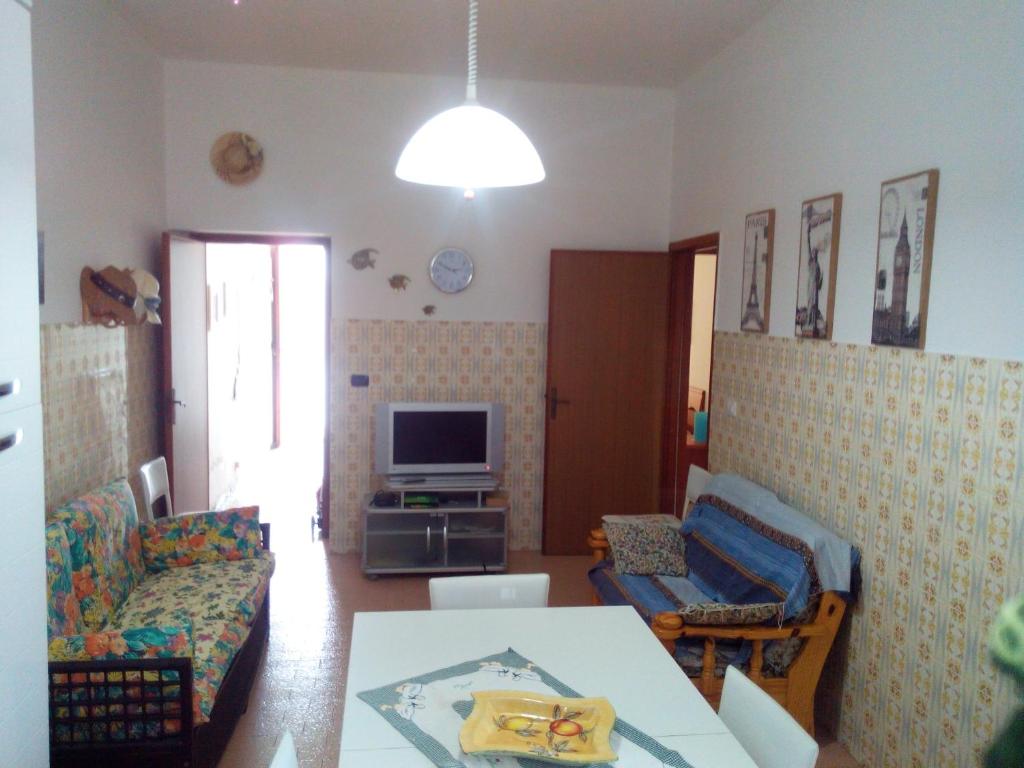 - un salon avec une table et une télévision dans l'établissement Appartamento Gianluca, à SantʼAntìoco