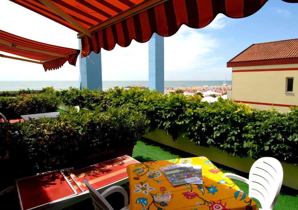 einen Tisch und Stühle auf einem Balkon mit Meerblick in der Unterkunft Hotel Righetto Fronte Mare in Cavallino-Treporti