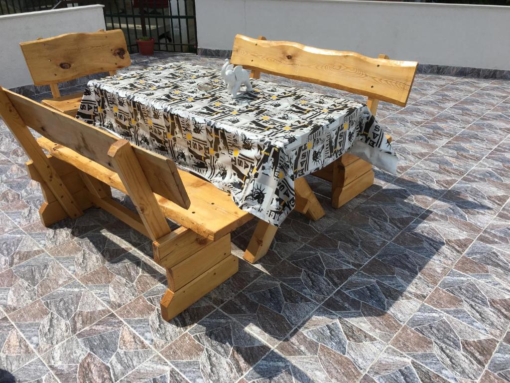a wooden table and bench with a table cloth on it at Apartment Sena in Sarajevo