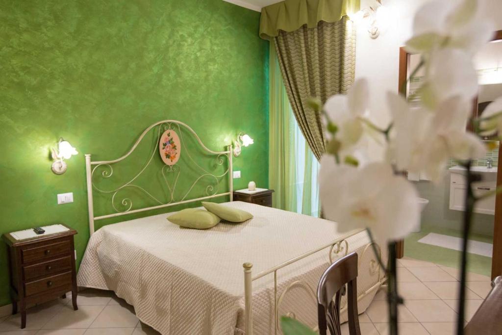 zieloną sypialnię z łóżkiem i zielonymi ścianami w obiekcie B&B Le due gioie w mieście Taviano