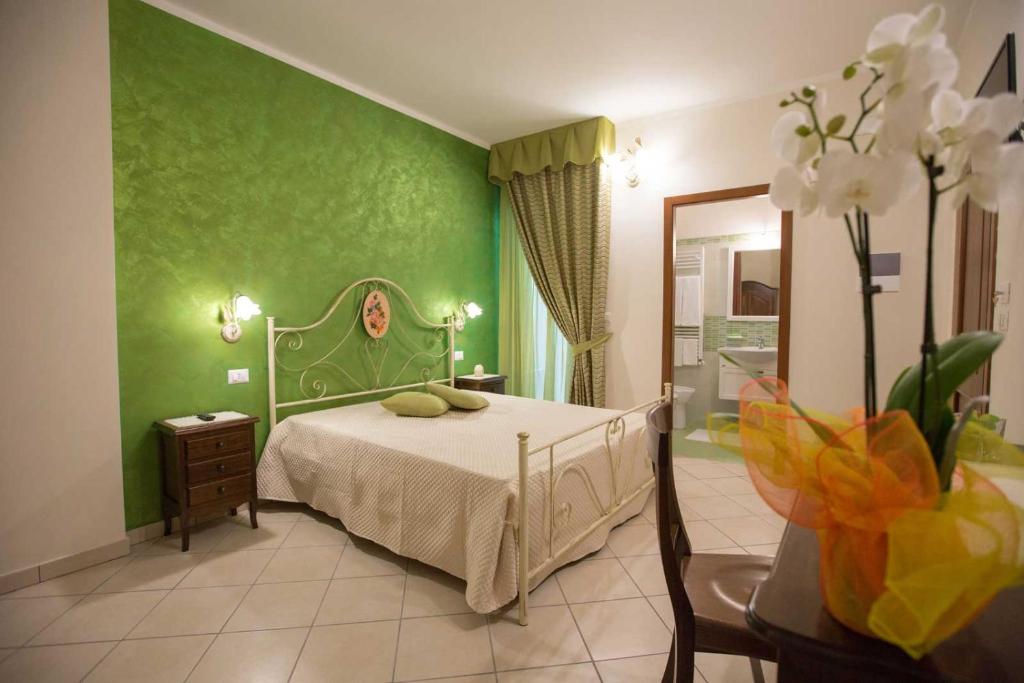 sypialnia z łóżkiem i zieloną ścianą w obiekcie B&B Le due gioie w mieście Taviano