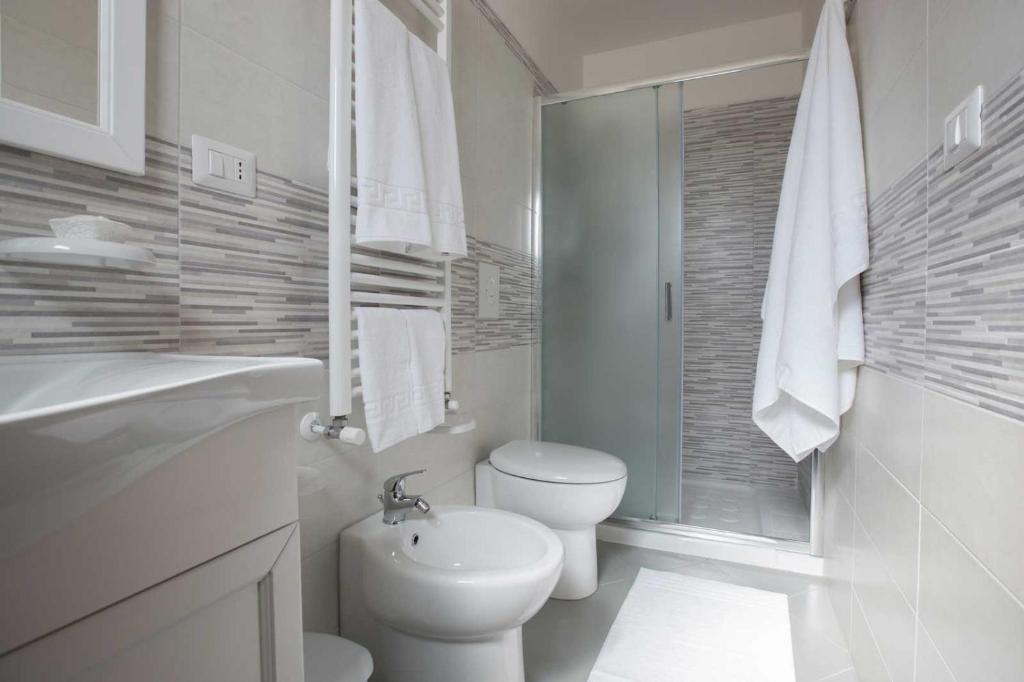 biała łazienka z toaletą i umywalką w obiekcie B&B Le due gioie w mieście Taviano
