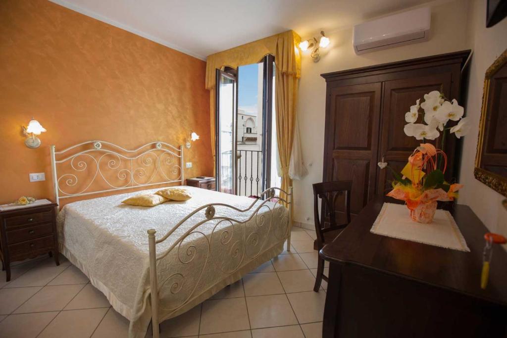a bedroom with a bed and a table and a window at B&B Le due gioie in Taviano