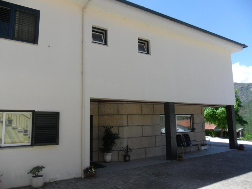 un edificio blanco con garaje con ventanas en Casa Da Veiga, en Gerês