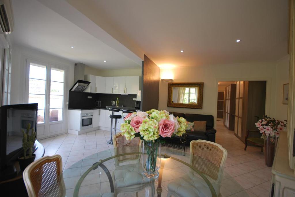 - un salon avec un vase de fleurs sur une table en verre dans l'établissement 2 Chambres Palais Justinia, à Cannes