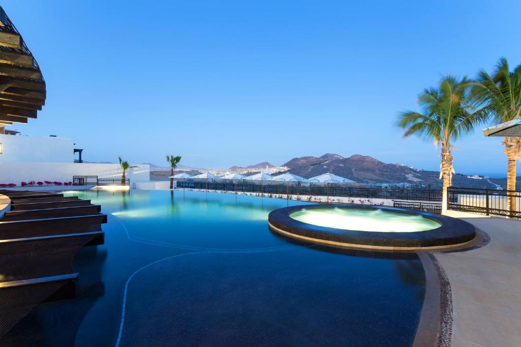 a swimming pool at a resort with palm trees at Quivira Los Cabos Condos and Homes -Vacation Rentals in Cabo San Lucas