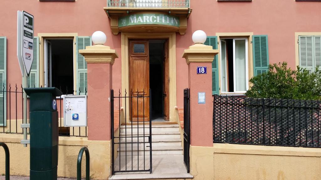 un bâtiment rose avec un portail et une porte dans l'établissement Hotel Marcellin, à Beaulieu-sur-Mer