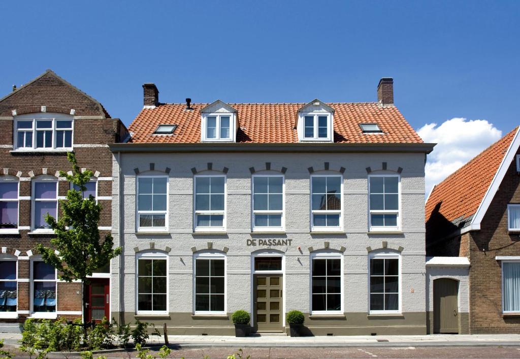 a large white building with a red roof at B&B De Passant in Breskens