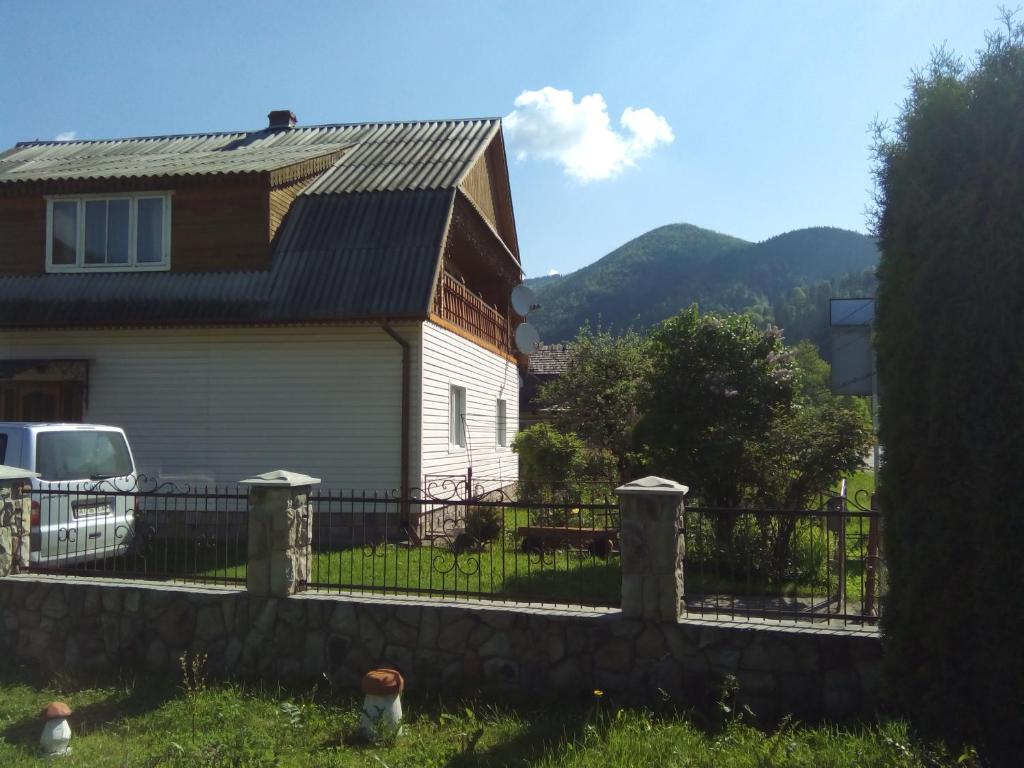 une maison avec une clôture devant elle dans l'établissement Homestay Opryshky, à Tatariv