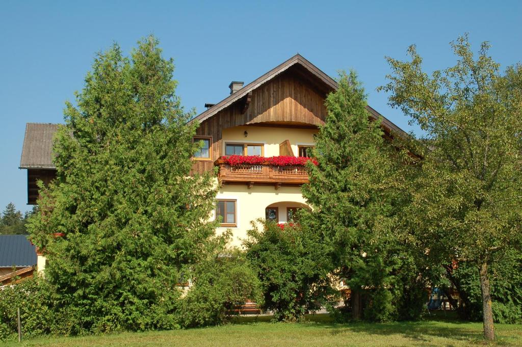 ein Haus mit einem Balkon zwischen zwei Bäumen in der Unterkunft Stroblbauernhof in Seeham
