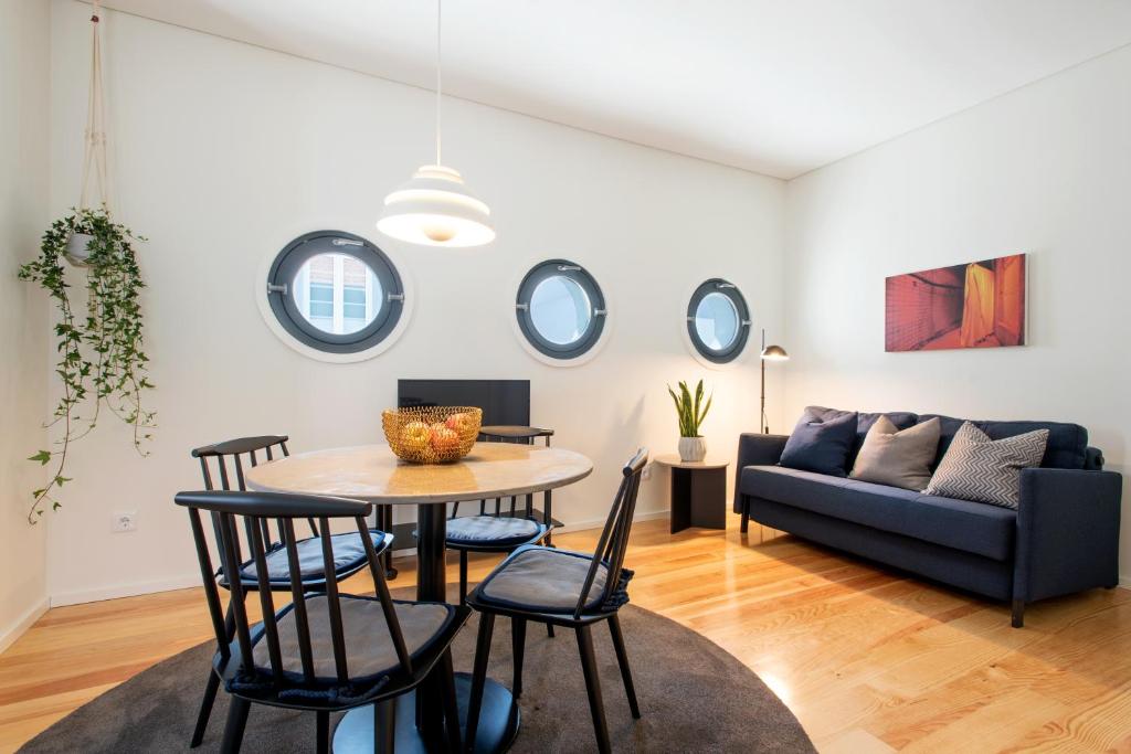 ein Wohnzimmer mit einem Tisch, Stühlen und einem Sofa in der Unterkunft Oporto Serviced Apartments - Alvares Cabral in Porto