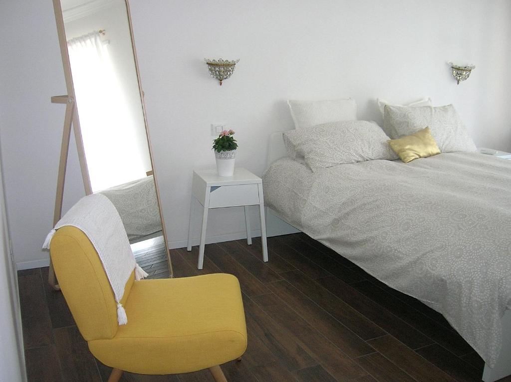 um quarto com uma cama e uma cadeira amarela em Centralissimo e luminosissimo apt a Roma em Roma
