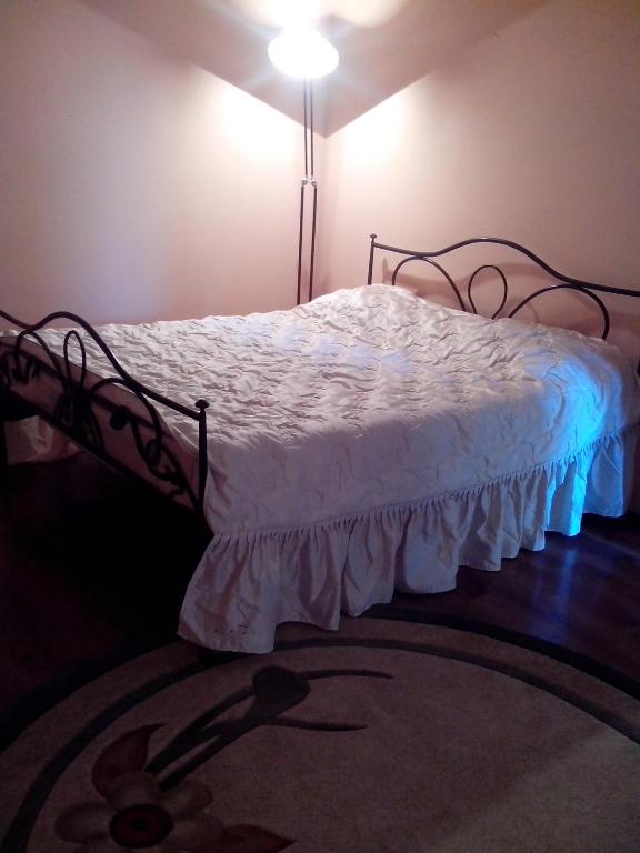 a bedroom with a bed with a white comforter at Apartment Na Saharova in Ivano-Frankivsk