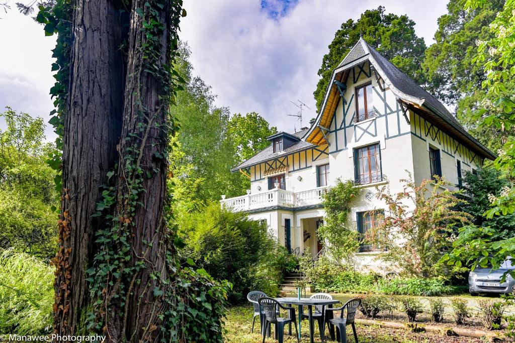 een groot wit huis met een tafel ervoor bij Villa Ariane in Saint-Jorioz