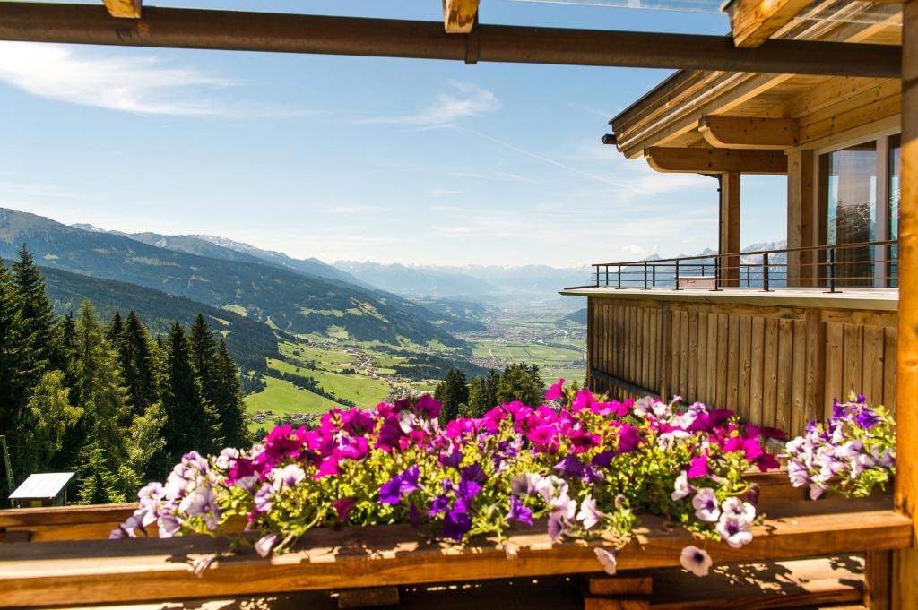 Un balcón con un ramo de flores. en Frieden DAS Alpine Panorama Hotel en Pill