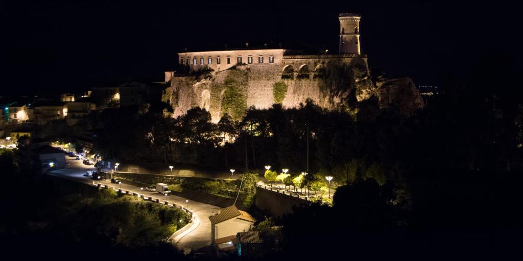 a castle on top of a hill at night at Castello Di Caccuri Suites in Caccuri