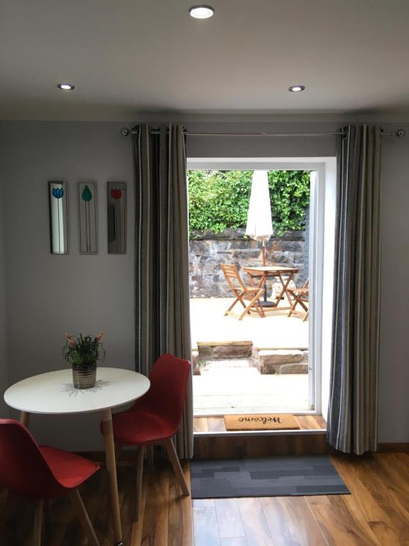 a dining room with a table and chairs and a sliding glass door at 32a railside in Inverness