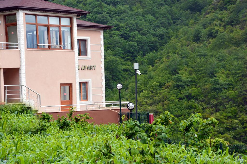 a building on the side of a hill with trees at Camlik Apart Hotel in Macka