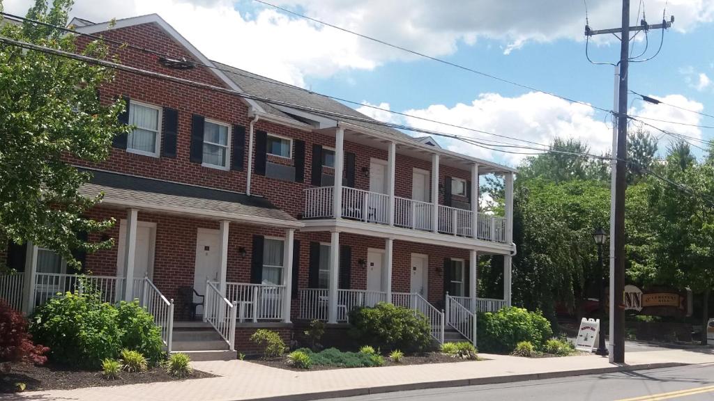 a red brick house with white balconies on a street at Inn at Cemetery Hill in Gettysburg