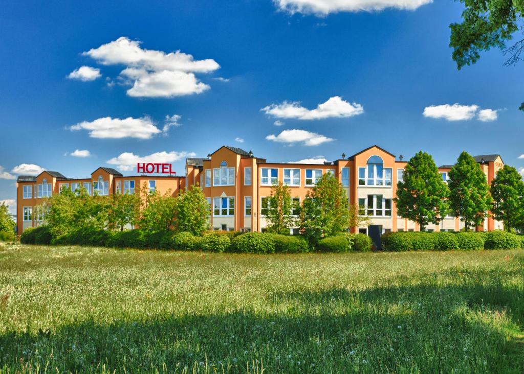 ein Hotel mit einem Grasfeld in der Unterkunft Grunau Hotel in Bayreuth